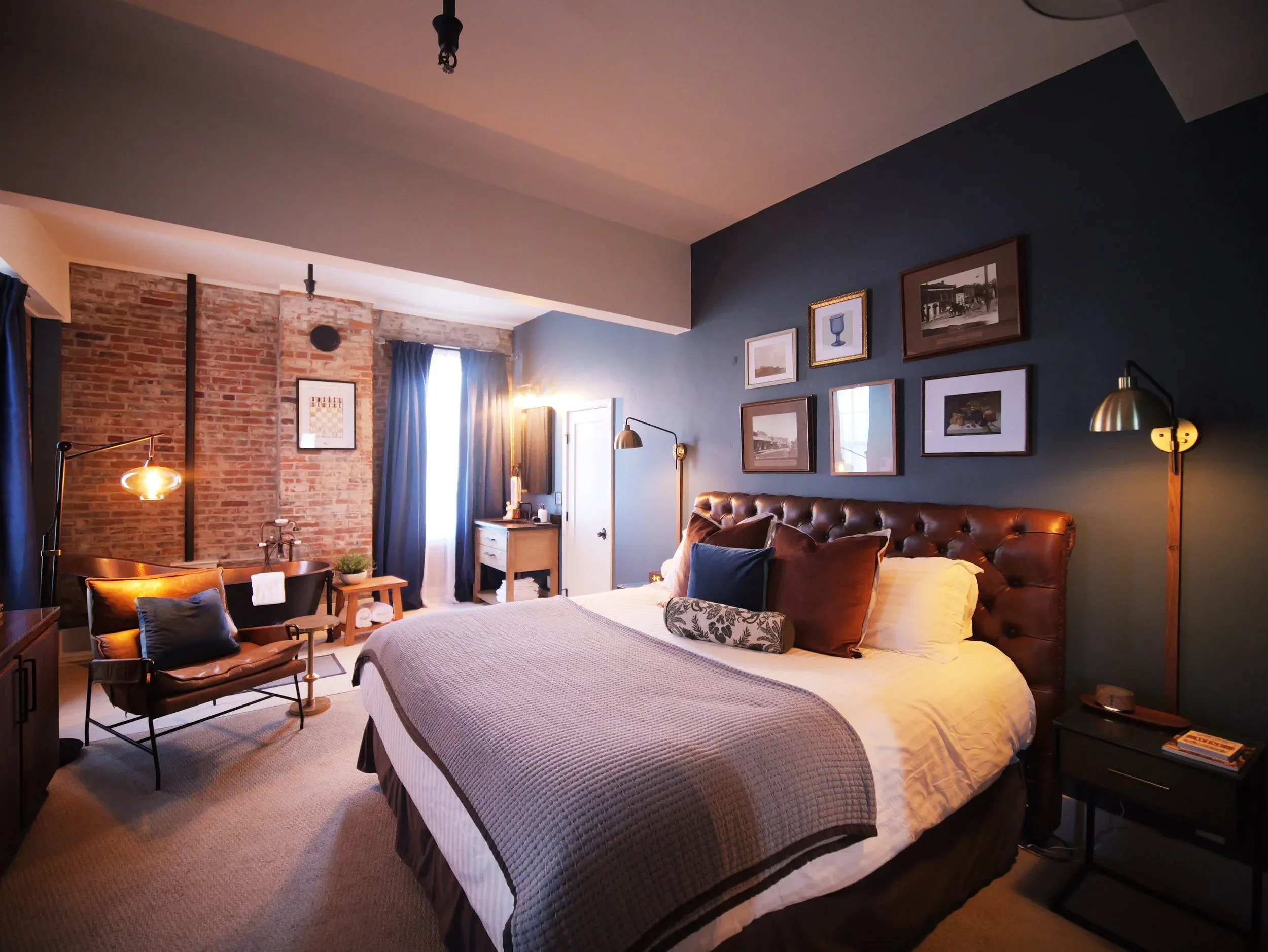 A guest room at the inn, brick and blue with a copper tub.